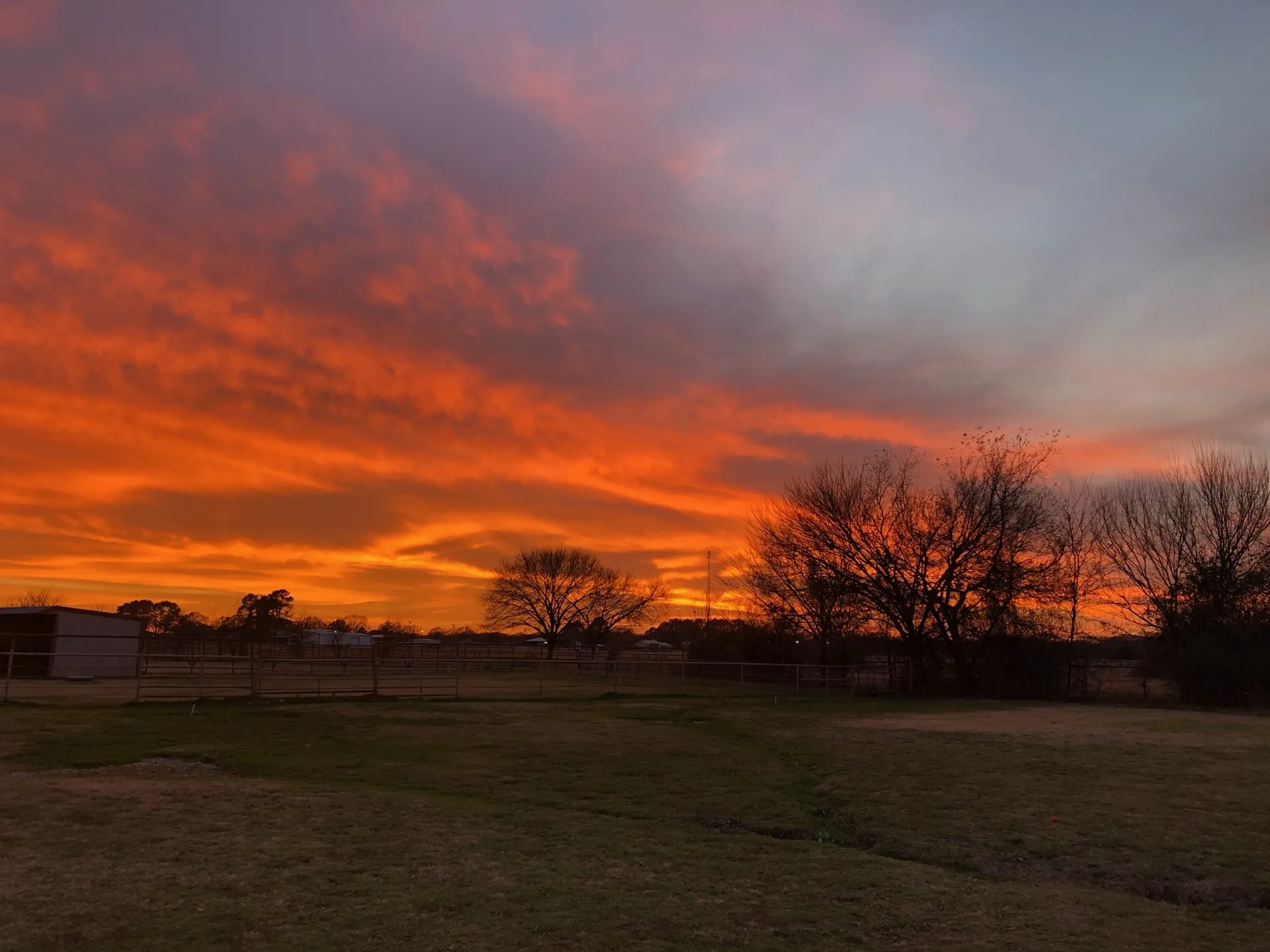 A fiery orange sunset over the ranch · Waggin' Tail Ranch RV Resort, Pilot Point, Texas